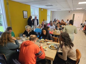 Verschillende tafels met etende mensen daaraan op de ADRA Contactdag.