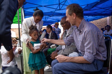 Geert geeft kleine klompjes aan de kinderen van de school.