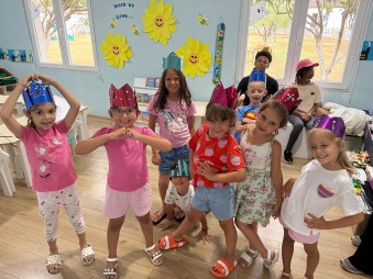 Kinderen kijken blij op de foto in de zaal waar het kinderprogramma is.