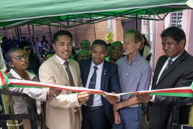 Directie en Geert Hendriks staan in een rijtje en knippen een lintje door.